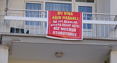 Ağır hasarlı pankartı asılan binayı görenler bir daha bakıyor